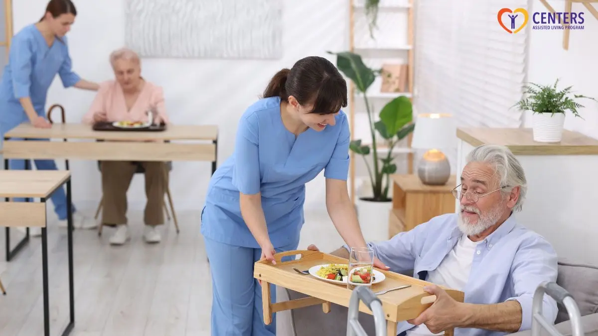 caregiver-serving-meal-to-senior-man-in-assisted-living-dining-room