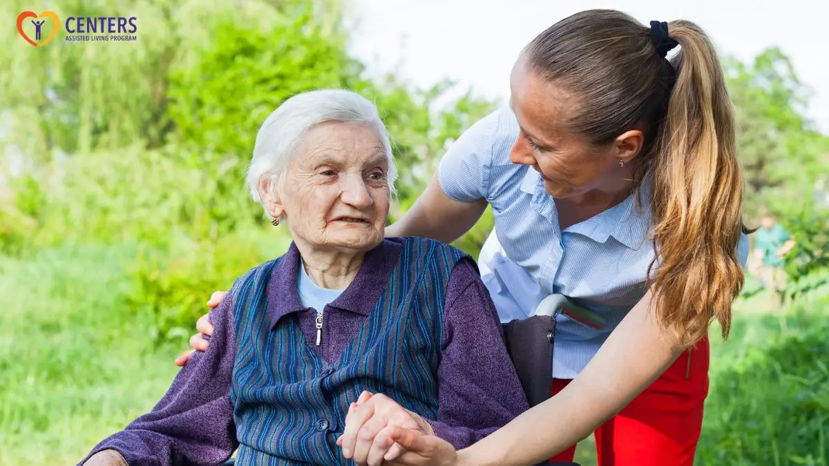 caregiver-supporting-elderly-woman-outdoors-centers-assisted-living