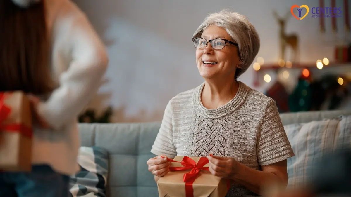 senior-woman-smiling-receiving-gift-box-at-home